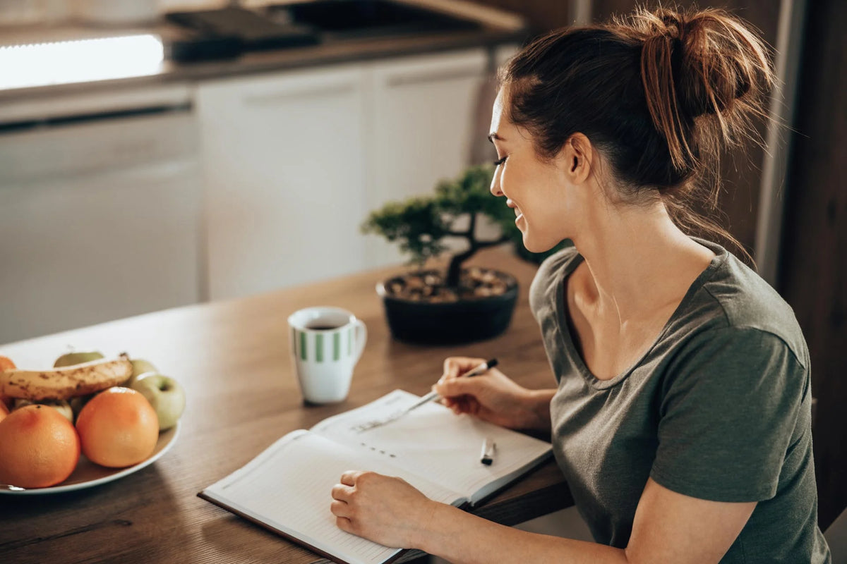 Junge Frau notiert sich all ihre Aufgaben in einer To-do-Liste 